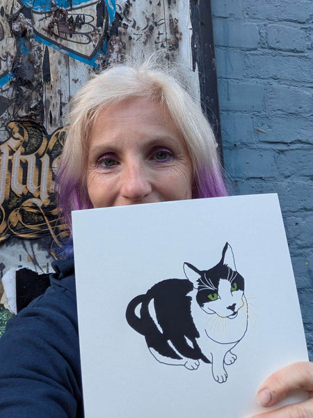 Print of a black and white  cat with green eyes held by Liz