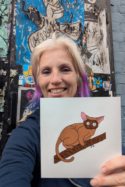 Liz holding a print of a Bush Baby