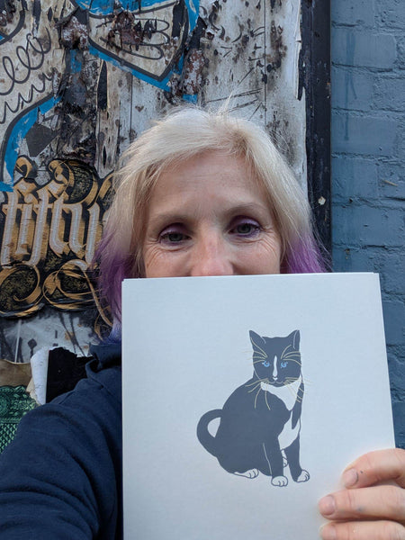 Print of a grey  cat with blue eyes held by Liz