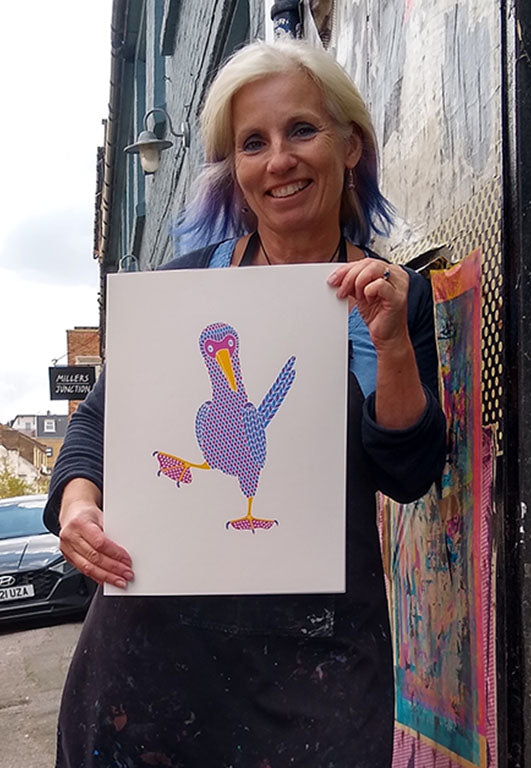 Liz Whiteman Smith holding her print of Jive dancing blue footed booby bird