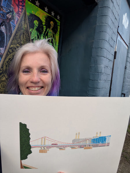 Print of Chelsea Bridge with Battersea Power Station in the background held by Liz