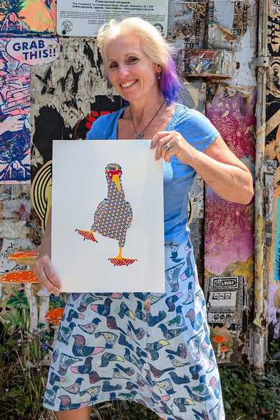 Liz holding Rainbow patterned dancing blue footed booby print