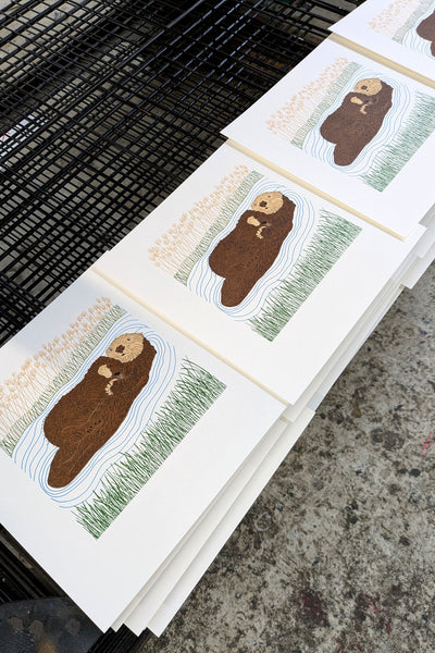 Print of otter mother and pup on the drying rack