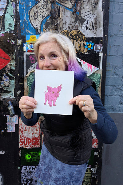 Print of a pink pig held by Liz