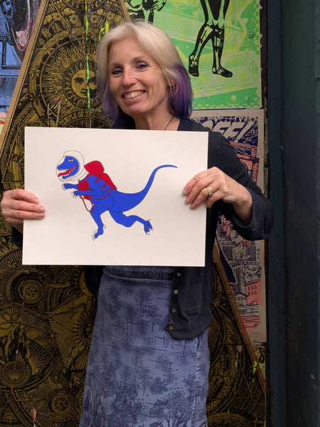 Print of blue velociraptor floating in Space held by Liz